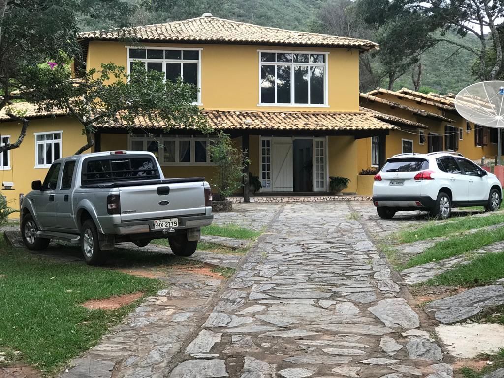A two-story yellow house with a stone pathway leading to the entrance.