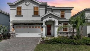 A two-story house with a garage, a front porch, and a stone facade. - Disney, Orlando, Treehouse, Arcade, Pool, Hot Tub! (Davenport)