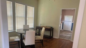 A dining area with a round table, four chairs, and a small side table. - The Big Pink
 (Nacogdoches)