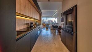Een moderne keuken met een centraal eiland, houten kastjes en een roestvrijstalen koelkast.