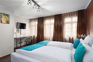 A hotel room with a bed, a desk, a chair, a television, and curtains. - Trip Inn Hotel Sachsenhausen (Frankfurt)