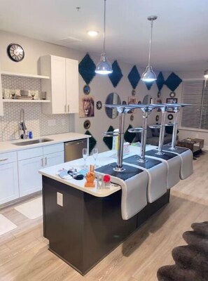 Enjoy cooking in this stylish kitchen with a central island, sink, and bar area.