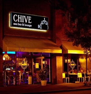 Enjoy a drink at Chive, a seaside bar with a welcoming entrance and outdoor seating area.