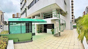 Un bâtiment moderne doté d’une structure surmontée d’un toit végétalisé, d’une cour dallée et d’un escalier en colimaçon.
