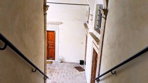 A narrow staircase with stone steps leading to a door at the top. - Elegance in Rome's Heart - Smart Lodging Prime (Roma)