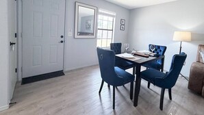 Uma sala de jantar com mesa, cadeiras e luminária.