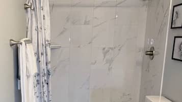 A bathroom with a shower, toilet, and a sink.