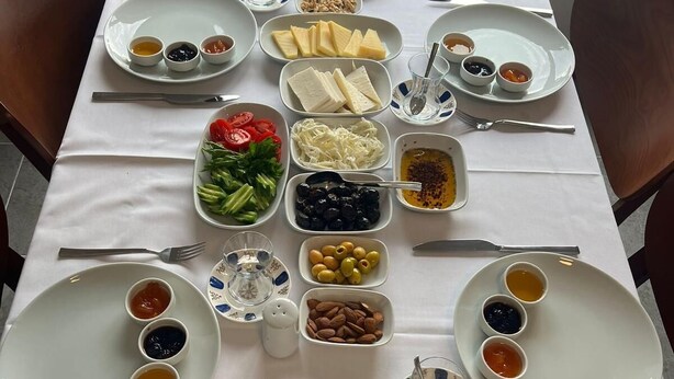 A table set for a meal with various dishes and condiments. - Troilus Park House Hotel (Eceabat)