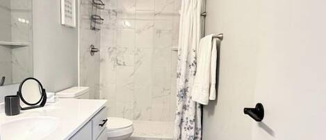 Un baño con ducha, inodoro y lavamanos.