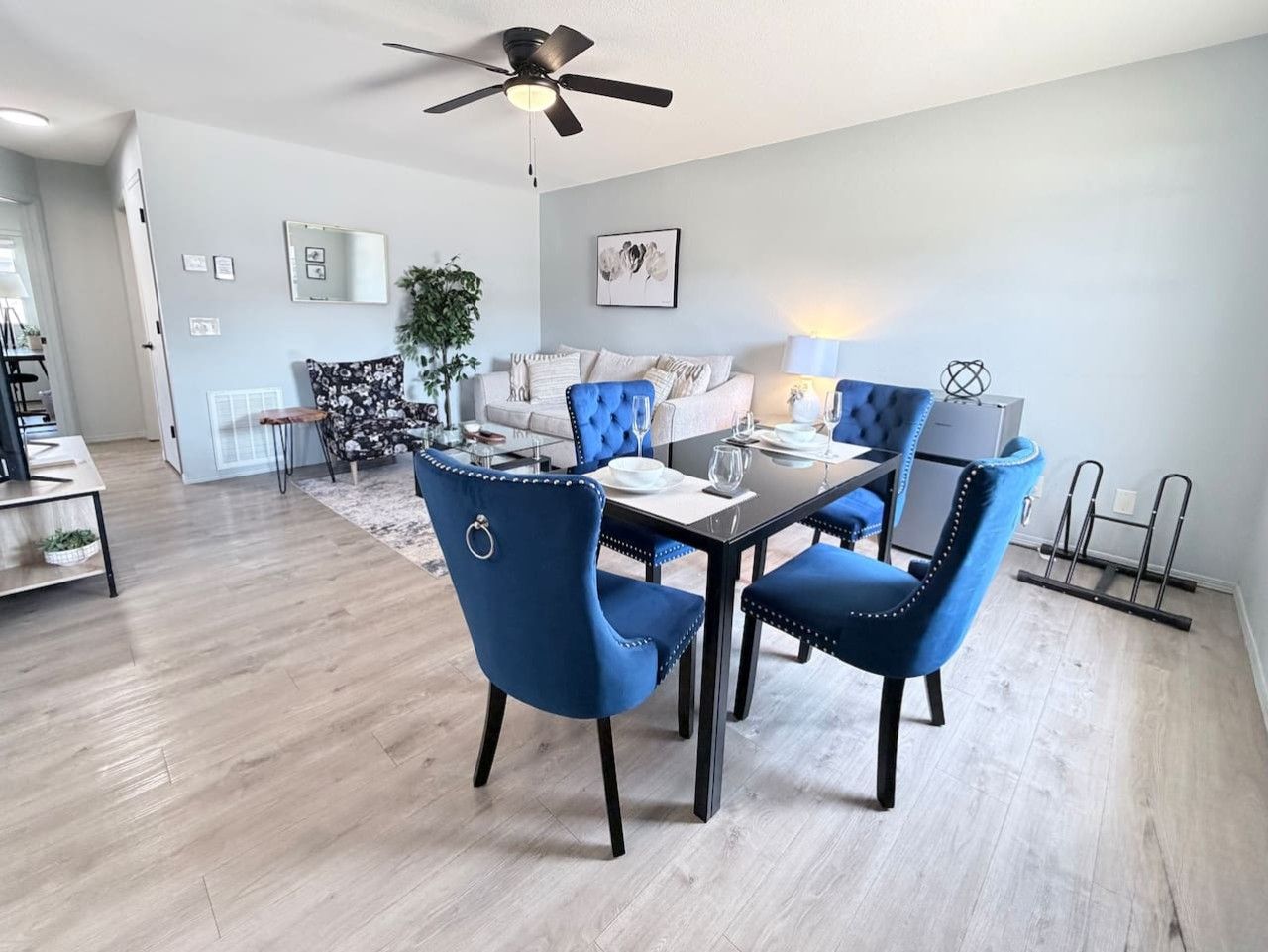 Un espace repas comprenant une table et des chaises, un ventilateur de plafond et un luminaire.