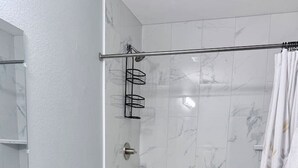 Casa de banho moderna com lavatório branco, sanita e área de duche.