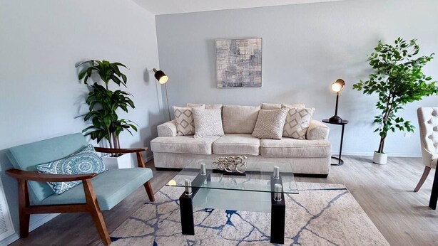 Sala de estar com sofá, mesa de centro e duas luminárias de chão.