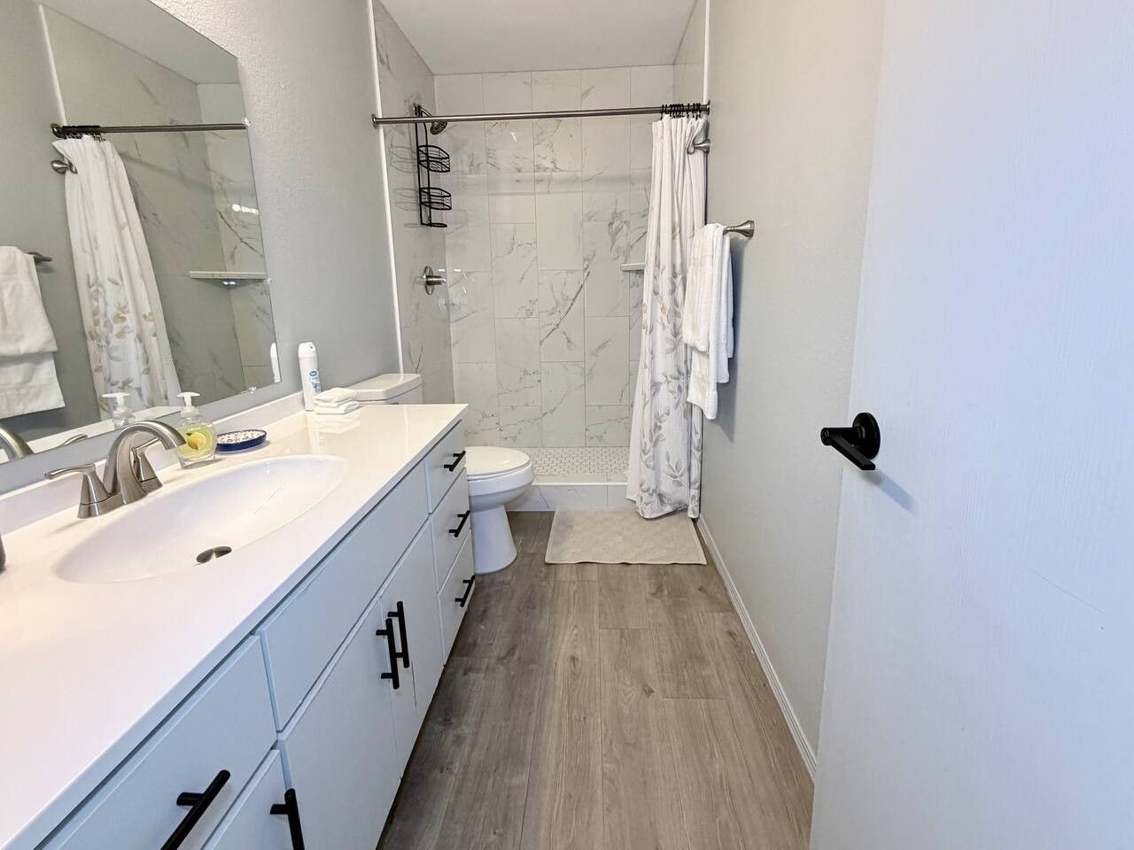 Une salle de bain moderne avec un lavabo blanc, un miroir et des toilettes.