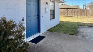 A single-story house with a blue front door, a small window, and a mailbox.