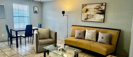 Una sala de estar con sofá, mesa de centro y ventilador de techo.