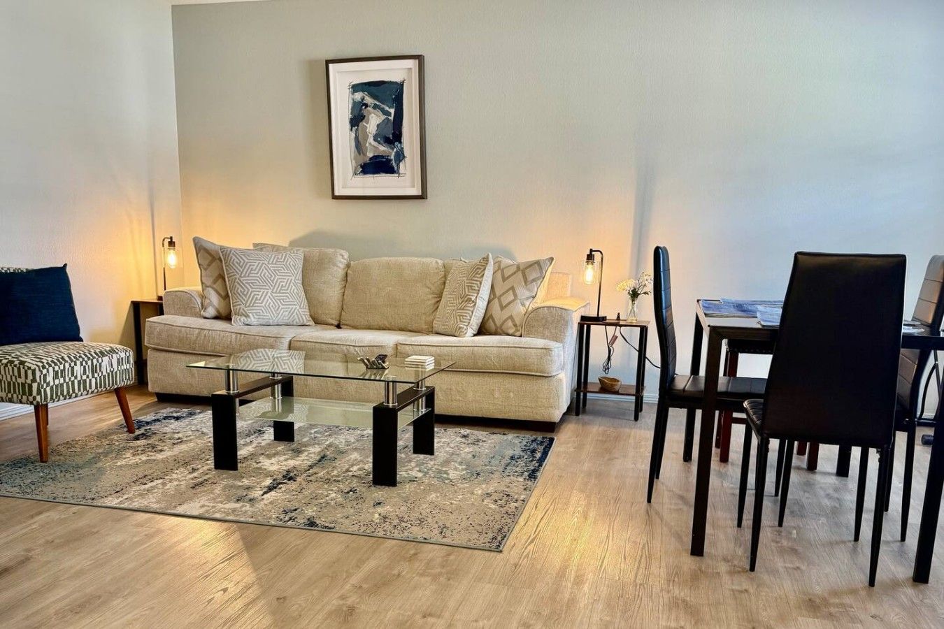 A living room with a sofa, coffee table, and a dining area with chairs.