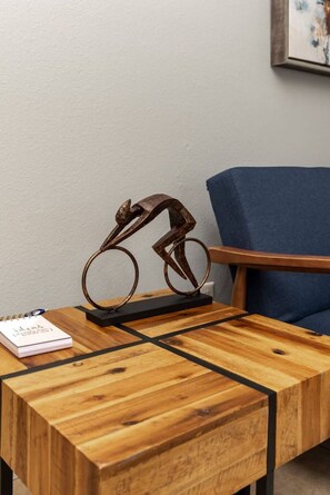 Uma mesa de madeira com uma escultura de metal, um caderno e uma caneta.