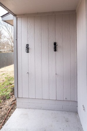 Une porte de garage dotée de deux poignées et d’une marche en béton menant à l’entrée.