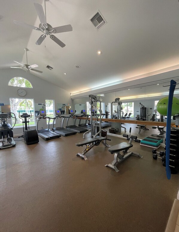 Un gimnasio con cintas de correr, elípticas y pesas sueltas.