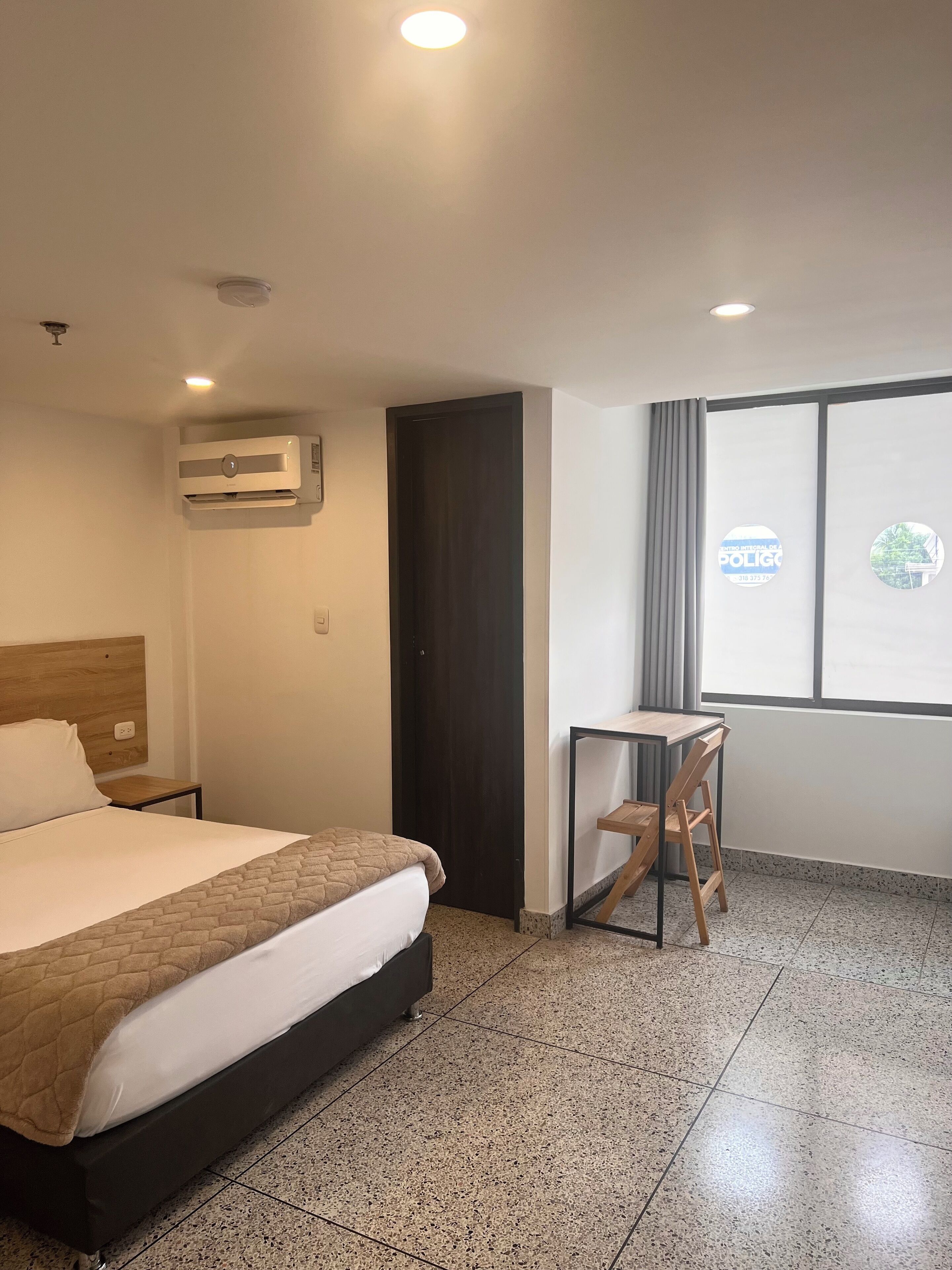 Une chambre d’hôtel avec un lit, un bureau et une fenêtre donnant sur un paysage agréable.