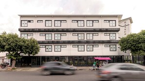 A multi-story building with a white facade and black-framed windows.