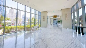A spacious lobby with large windows, a marble floor, and modern furniture. - Luxury StayCation - Incredible Sea View Apartment With Balcony (Dubai)