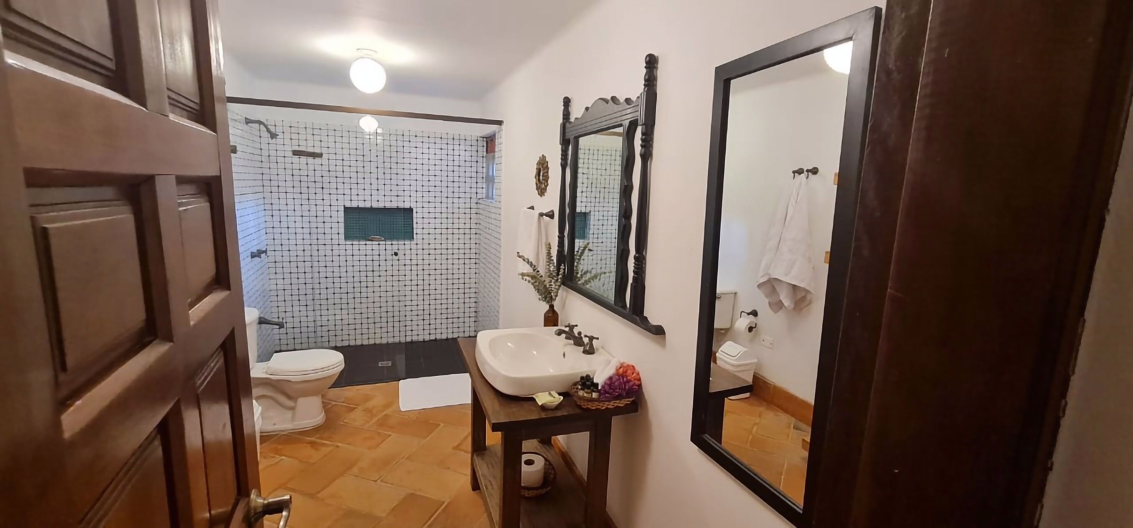 Un baño con inodoro, lavamanos y espejo.