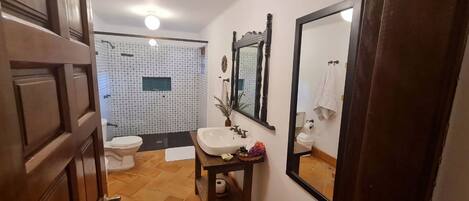 Un baño con inodoro, lavamanos y espejo.