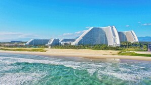 A beachfront hotel with multiple high-rise buildings, a sandy beach, and clear blue skies. - Cam Ranh Nha Trang Seaview Condotel (Bac Cam Ranh)