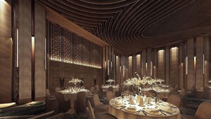 A modern hotel dining area with round tables, elegant decor, and a unique ceiling design. - Cam Ranh Nha Trang Seaview Condotel (Bac Cam Ranh)