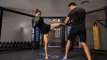 A mixed martial arts training area with a punching bag, a water bottle, and a logo for Aqua Gym.