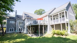 A two-story house with a covered porch and a fenced backyard.