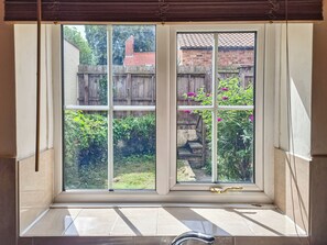 A room with a large window, a wooden door, and a tiled floor. - Escape to this wonderful holiday cottage in Helperby, North Yorkshire. (Helperby, near Thirsk)