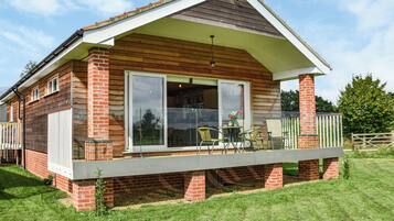 A two-story house with a balcony, large sliding glass doors, and a brick exterior.