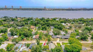 An aerial view of a residential area with houses, greenery, and a large body of water in the background. - Dragonfly Landing: Close to Everything (Daytona Beach)
