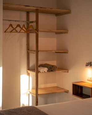 Een houten schapunit met verschillende vakken, waarvan enkele gevuld zijn met opgerolde handdoeken.