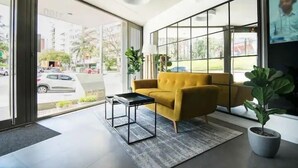 Een modern interieur met een bank, een kleine tafel en een kamerplant.