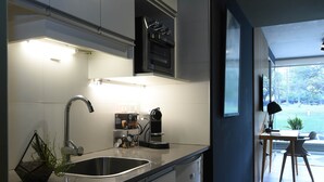 Een moderne keuken met een roestvrijstalen spoelbak, een koffieapparaat en een inbouwoven.
