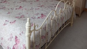 Une chambre à coucher avec un lit, une armoire en bois et une table de chevet.