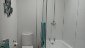 Une salle de bain moderne équipée de toilettes, d’un bidet et d’une baignoire.