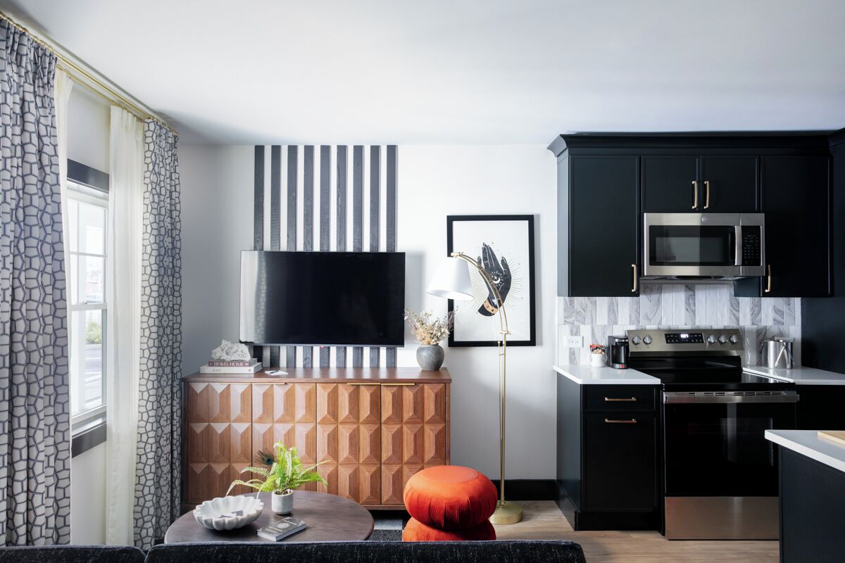 A modern kitchen with black cabinets, a stainless steel microwave, and a black stove.