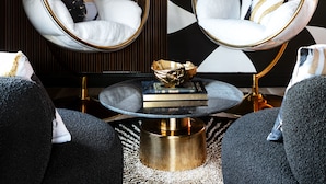 A modern living room with two hanging chairs, a round coffee table, and a bookshelf. -  The Cove At Salem (Salem)