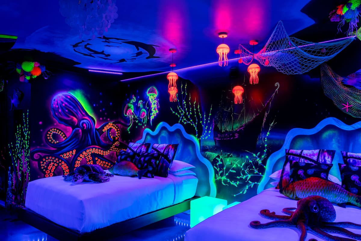 A room with a bed, a large octopus decoration, and jellyfish hanging from the ceiling.