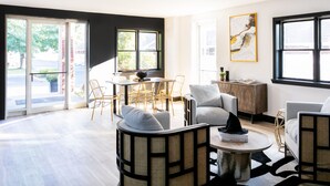 A modern living room with a dining area, large windows, and a view of the outdoors. -  The Cove At Salem (Salem)