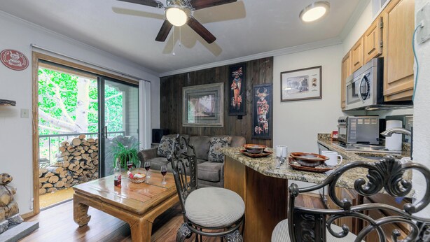 A modern kitchen with a central island, wooden cabinets, and a ceiling fan. - Hunter's Lodge by Ruidoso Vacation Rentals (Ruidoso)