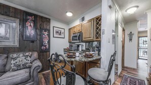 A modern kitchen with wooden cabinets, a granite countertop, and stainless steel appliances. - Hunter's Lodge by Ruidoso Vacation Rentals (Ruidoso)