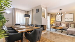 Un salon moderne comprenant un canapé, une table basse et un coin repas avec une table et des chaises.