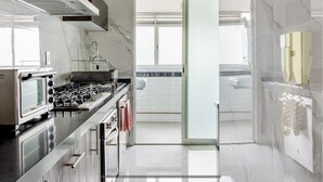 A modern kitchen with a gas stove, oven, and stainless steel appliances. There is a glass door leading to another room. - 4 Hip&Chic Apts + Private Rooftop in the same building in Exclusive Roma Norte (Ciudad de México)