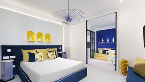 A modern bedroom with a large bed, bedside tables, and a view into the adjacent living area.