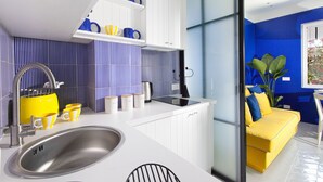 A modern kitchen with a stainless steel sink, white cabinets, and a yellow countertop.